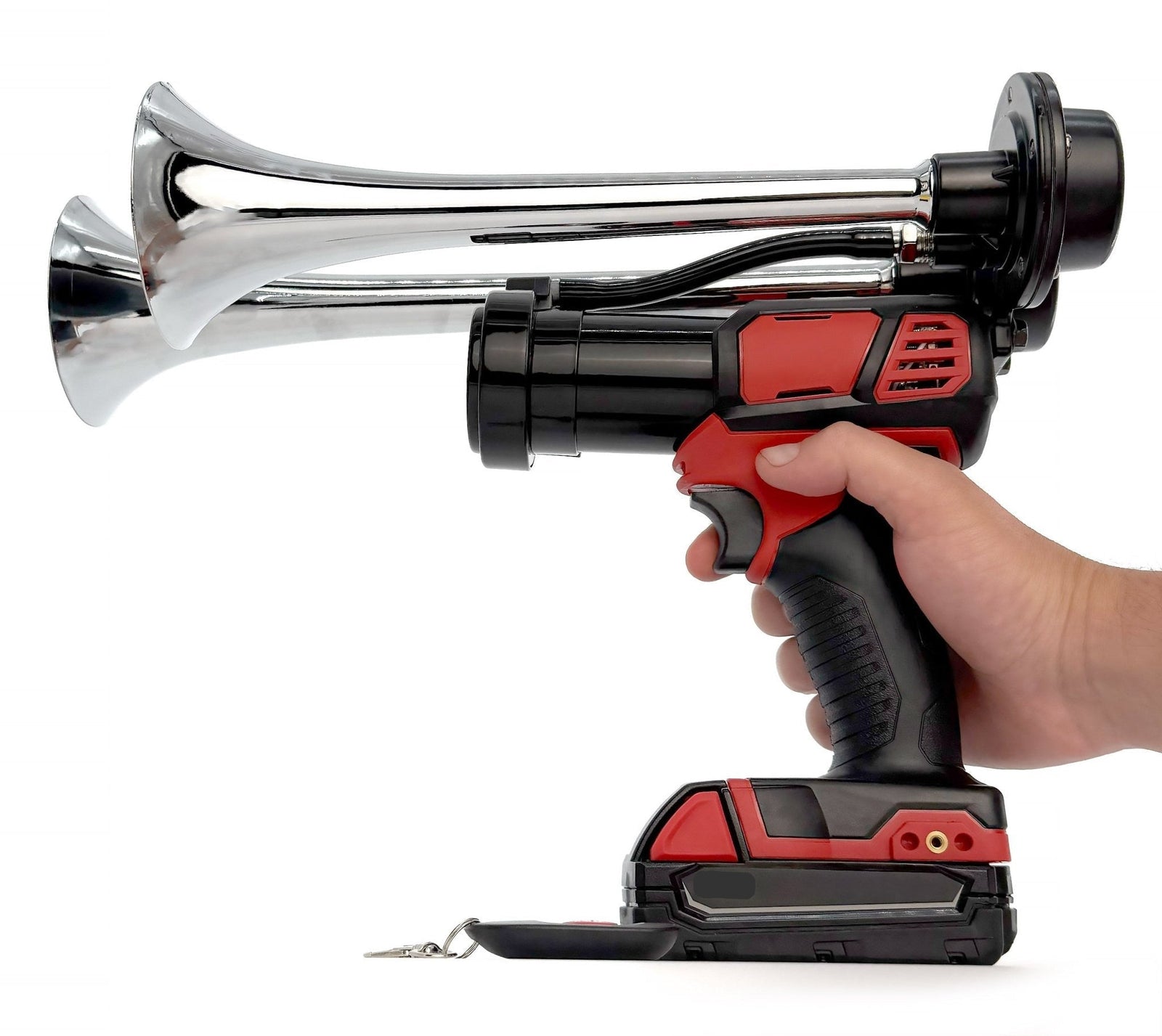 Hand gripping the chrome battery powered train horn by its handle, key fob remote on the table - view 9
